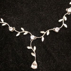 Silver crystal necklace with leaf pattern.
